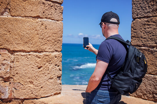 Happy tourist man visiting Essaouira, Marrakech, Morocco. Taking mobile phote picture