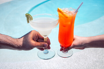 Male and female hands hold out glasses with tasty cocktails for a toast
