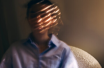 Close-up portrait of a young woman in casual clothes taken at long exposure