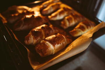 Close-up of delicious mouth-watering hot croissants on a baking sheet from the oven. Delicious...