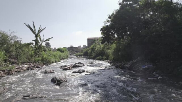 Low flying drone shot of a dirty river in Dandora dumpsite in Nairobi Kenya