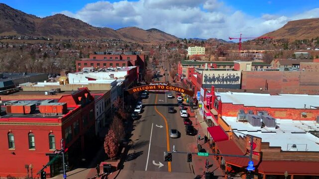 Welcome to historic downtown Golden Colorado aerial drone Coors Beer Factory North Table Mountain Mesa Golden Gate Canyon winter sunny morning afternoon blue sky businesses buildings cars upwards