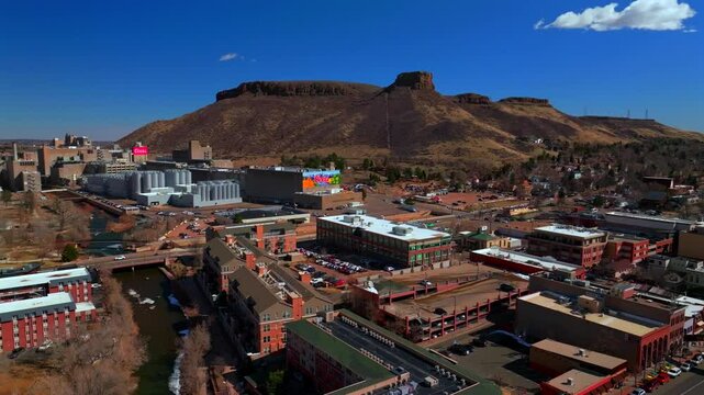 Historic downtown Golden Colorado aerial drone Clear Creek River North Table Mountain Coors Beer Factory Golden Gate Canyon winter sunny morning afternoon blue sky businesses buildings car pan left
