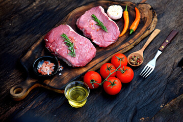 Banner Raw meat beef steak organic fresh ingredient on wooden board table background in kitchen with rosemary, salt, garlic, tomato, olive oil. Meat beef on wooden plate for beefsteak with copy space