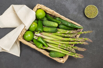 Mash, bulgur and nuts in bowls. Asparagus, cucumbers and lime in rattan basket