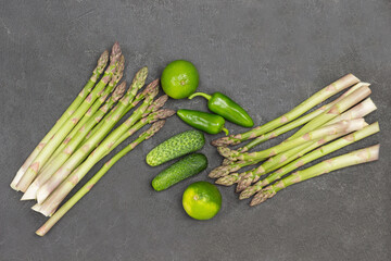 Asparagus, green peppers and cucumbers on table.