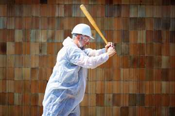 Man in full safety gear prepares to hit with baseball bat. Rage room or smash therapy concept.