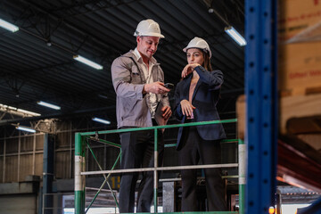 Distribution warehouse manager and client businesswoman using digital tablet checking inventory...
