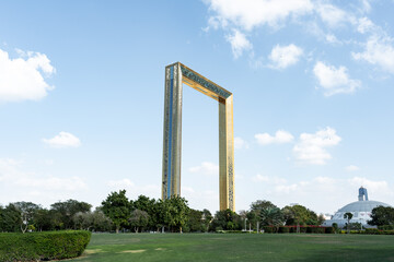 Dubai frame standing tall in zabeel park on sunny day with blue sky and clouds
