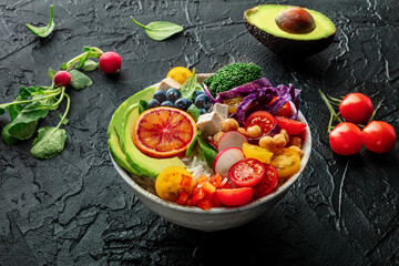Buddha Bowl. Rainbow salad. Vegan poke bowl with avocado. Healthy food, fresh organic ingredients on a black table
