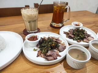 Top shot Sei Beef dish typical of East Nusa Tenggara, Indonesia. Smoked meat cuisine known as Sei is served with cassava vegetables and broth and iced tea or iced coffee. Food and beverages themes