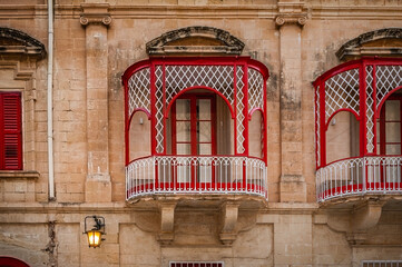 Colorful traditional balconies of Maltese in the ancient city of Mdina, Malta. Maltese residential architecture, windows.