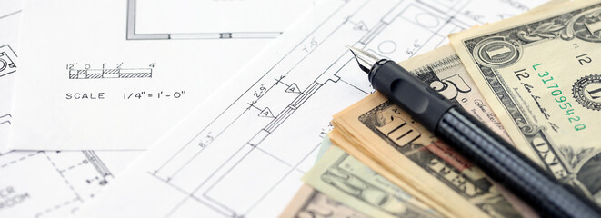Big amount of US dollars money bills with pen and planning blueprints of residential building project close up. Investment and construction project concept