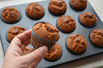 Closeup of a hand holding a freshly made home cooked cupcake