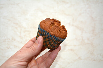 Closeup of a hand holding a freshly made home cooked cupcake