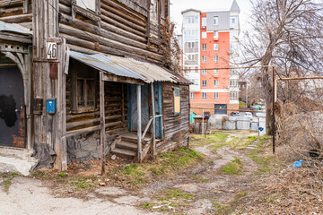 Old 1903 two-story gnarled crumbling wooden apartment building with a toilet in the street against...