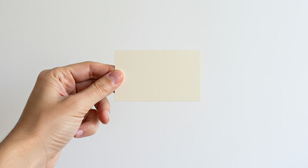 Fototapeta premium Minimalist Message: Hand Holding a Blank Card