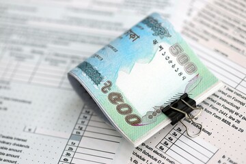 Bangladeshi taka money bills in big amount lies on table with tax forms close up. Accounting and...
