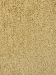 Fototapeta premium Yellow textured wall with decorative plaster finish in bark beetle style, close-up surface background for design and interiors