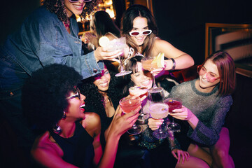 Group of friends toasting cocktails at a vibrant nightlife celebration