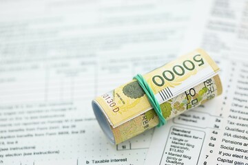 South Korean won money bills in big amount lies on table with tax forms close up. Accounting and...