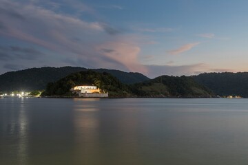 Santos city, Brazil. Barra Fortress in the port channel of Santos city at night. Trace of red light from the boat that passed in front.