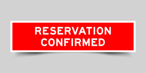 Red color square shape sticker label with word reservation confirmed on gray background