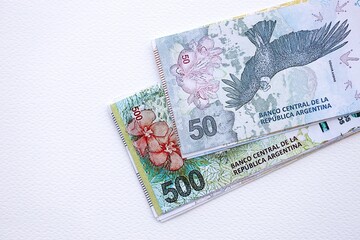 Argentine pesos money bills in big amount lies on white table close up