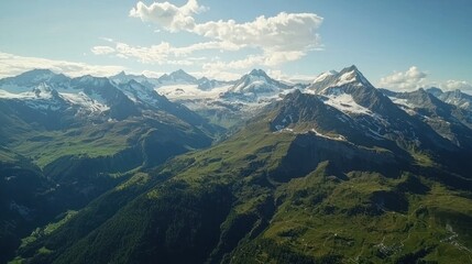 Fototapeta premium A stunning aerial view of the Swiss Alps, with snow-capped peaks and green valleys