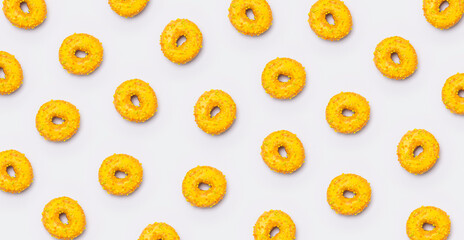 Fototapeta premium Sweet yellow glazed donuts with sprinkles on light gray background flat lay top view. Abstract background with food, sugar dessert, round tasty donut, pattern. Snack, fast food to go