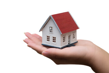 A miniature white house with a red roof is held in the palm of a hand against a black background scene on transparent background