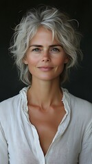 Woman with short gray hair, wearing a white blouse