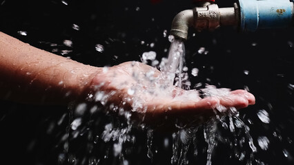 Purified Flow: A hand catches the clear stream from a tap, depicting the purity and essence of...