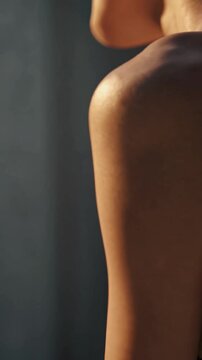 &Eacute;paule et nuque d&rsquo;une femme &eacute;clair&eacute;es par une lumi&egrave;re douce

