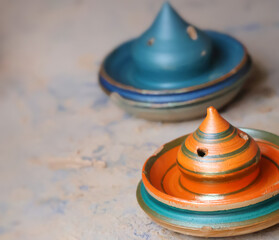 Colorful wet clay art moulded by indian potters and kept for drying with bokeh background of other clay pots.Image for pottery,artwork,workshops,webinars,creation,craft.Complex clay sculpture display