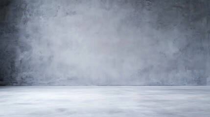 Fototapeta premium Minimalist empty concrete room with a textured gray wall and smooth floor.