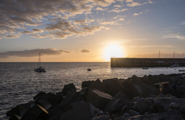 Golden sunset view of Playa de San Juan bay with protected sand beach and small harbor. Playa de San Juan is a small fishing village on the south west of Tenerife island.