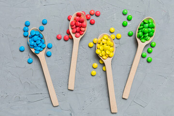 delicious colorful sweet candies on spoon on colored background . Confectionery decor top view with copy space