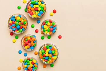different colored round candy in bowl and jars. Top view of large variety sweets and candies with copy space