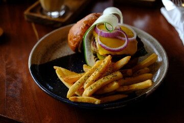 Gourmet Burger with French Fries, Garnished with Cucumber and Onion Slices