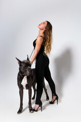 Beautiful slender model dressed in the black suit with dog
