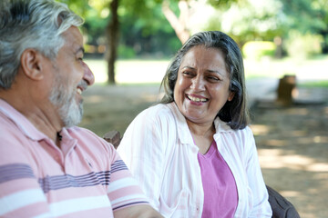 Obraz premium Indian Happy Senior Couple having fun and spending quality leisure time in vacation time after retirement at park. Concept of senior citizen living