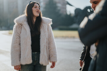 Group of friends outdoors, engaging in conversation while enjoying a sunny day together. Captures a moment of camaraderie and lighthearted interaction in an urban park setting.