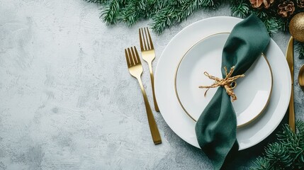 Stylish holiday dinner setting with white plates, golden flatware, and lush green napkins on a cool concrete table.