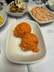 Muhammara, sauce of wholesome walnuts and roasted red bell peppers on a ceramic white plate
