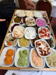 Meze of Luxury table with plate of fish, meat, pickles, antipasto, aubergine, appetizers, cheese, mezze, salad, octopus, raki and ouzo.