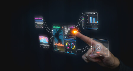 A hand interacts with futuristic digital data interfaces displaying colorful analytics and graphs on a dark background.