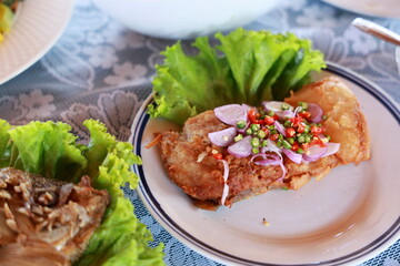 Sour fish : Thai Spicy fermented fish with herbs deep-fry until crispy and add sliced ​​shallots, chopped chili peppers, green salad. Squeeze lemon juice. Prepare of ready-made spicy fermented fish.
