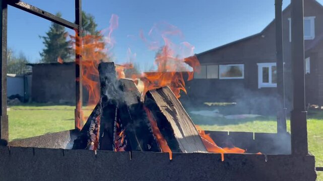 Burning dacha brazier. Summer barbecue in the nature. A sunny summer day.