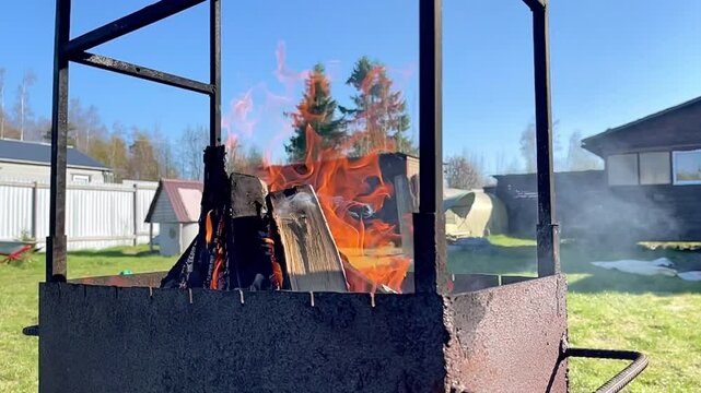 Burning dacha brazier. Summer barbecue in the nature. A sunny summer day.